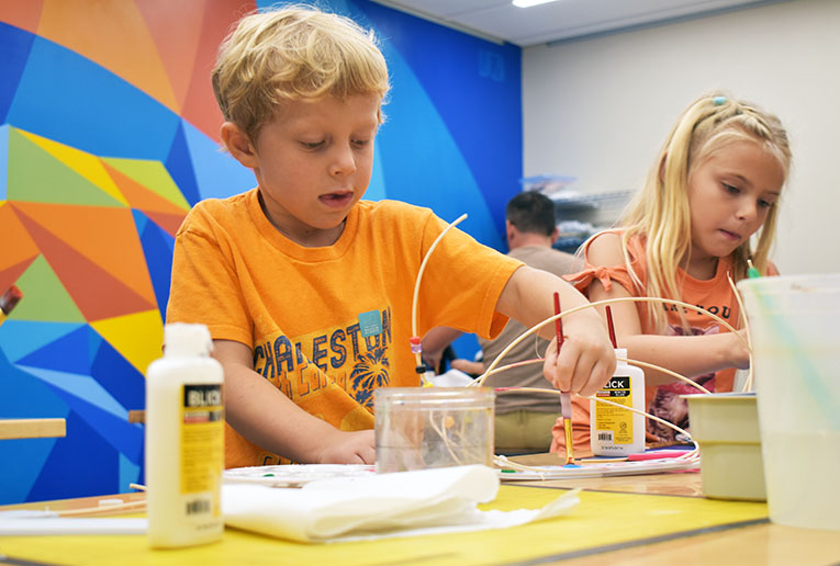 Children crafting at a colorful art table.