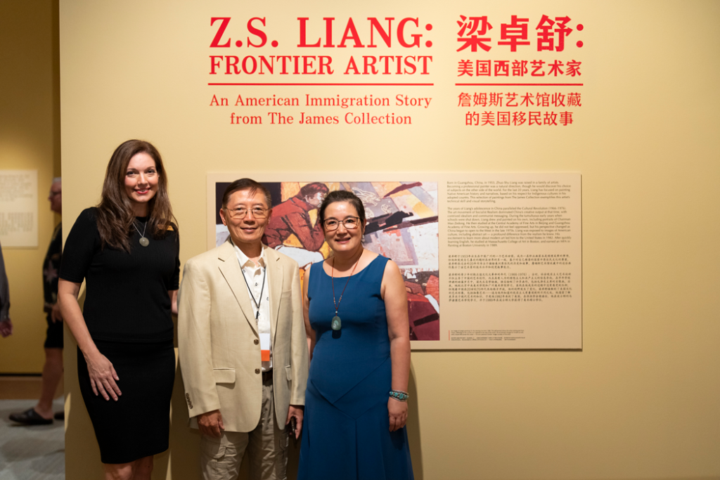 Artist Z.S. Liang and his wife stand in front of the exhibition with the curator, Emily Kapes.