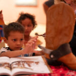 Child interacting with a cowboy boot