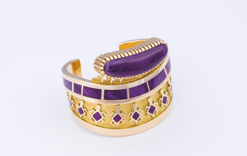 Gold cuff bracelet with purple enamel and gemstone inlays, featuring geometric cutouts and a raised, oblong purple stone on top—a true Jewel Box treasure.