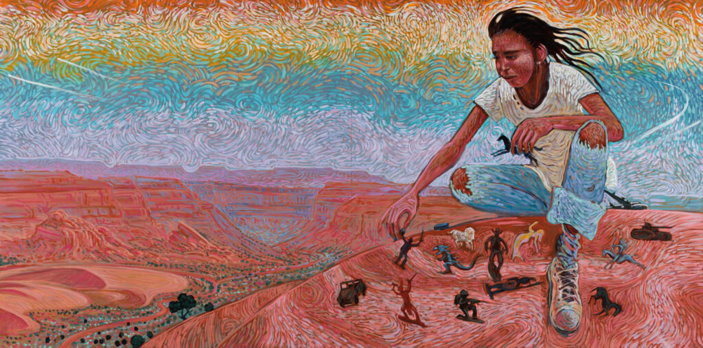 A person in a white t-shirt and jeans crouches on a colorful, painted desert landscape, arranging small animal figures on the ground under a swirling sky reminiscent of works seen in a Native art gallery.