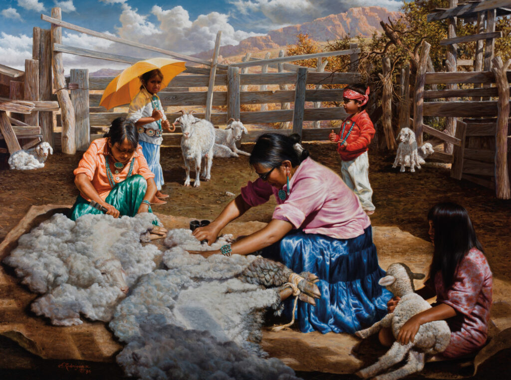Two women shear sheep wool in a pen while three children, one holding an umbrella and another a toy sheep, look on; goats and lambs are visible in the background at the Native Life Gallery.