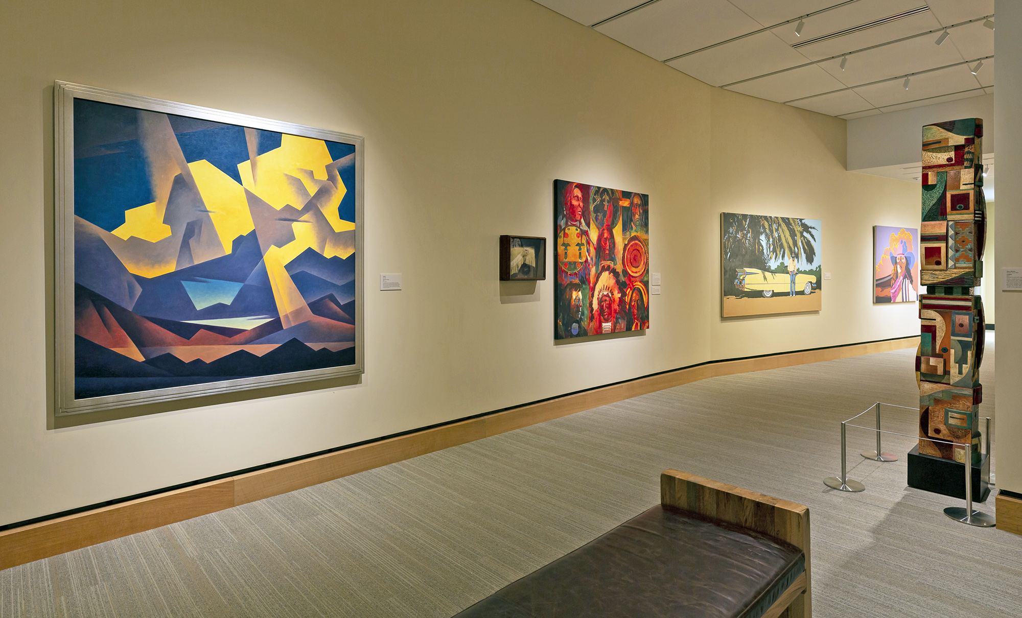 A modern art gallery, New West Gallery, features colorful abstract and landscape paintings on cream walls, a wooden bench in the foreground, and a tall mixed-media sculpture on the right.
