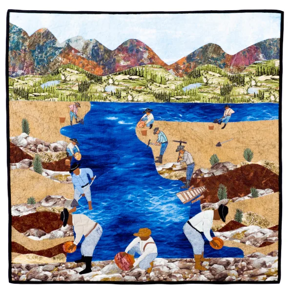 A quilt depicts Black Pioneers panning for gold along a river, with mountains and trees in the background, capturing a legacy of resilience in the American West.